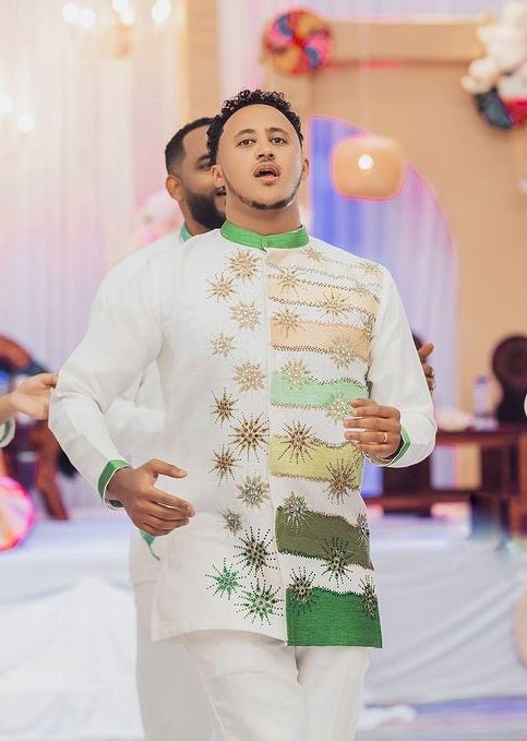 Man wearing a traditional outfit with intricate patterns in a festive setting