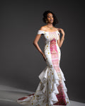 Model wearing a white dress with colorful patterns on a dark background
