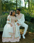 Couple in formal attire sitting on a bench in a garden setting